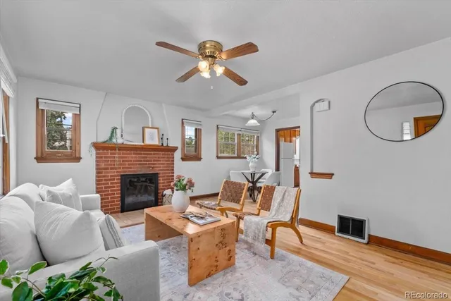 a living room with furniture a fireplace and wooden floor