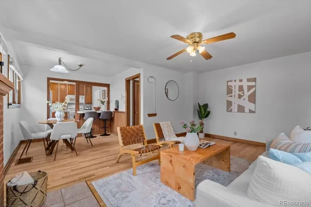 a living room with furniture kitchen view and a chandelier