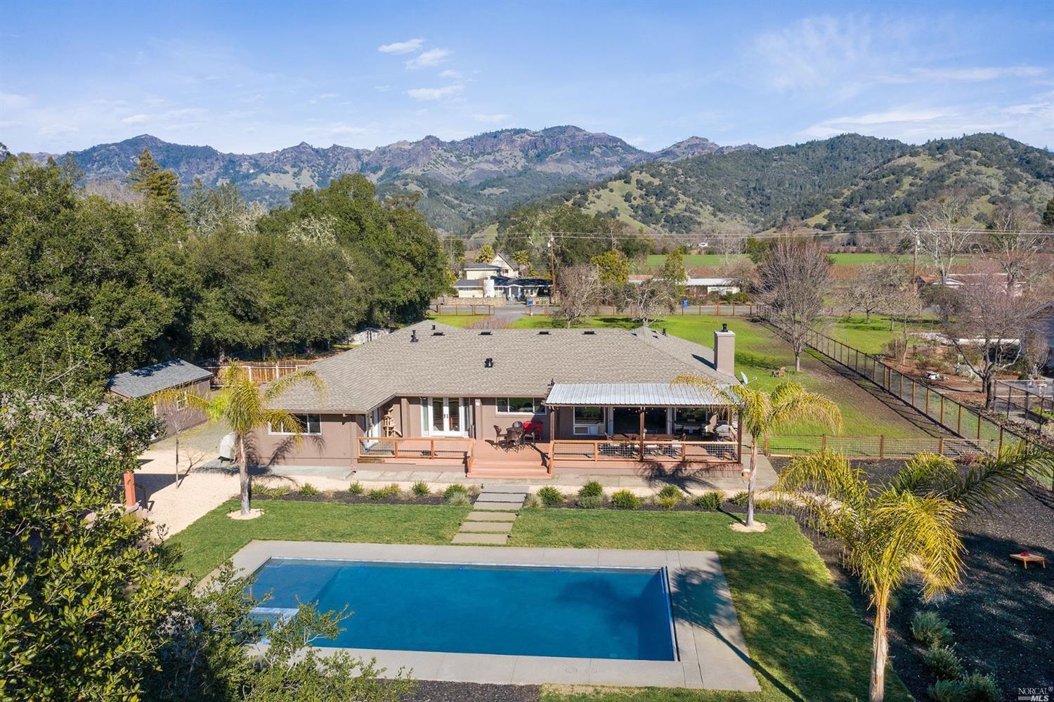 an aerial view of a house with a garden and lake view