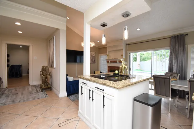 a kitchen with kitchen island granite countertop a stove refrigerator and cabinets