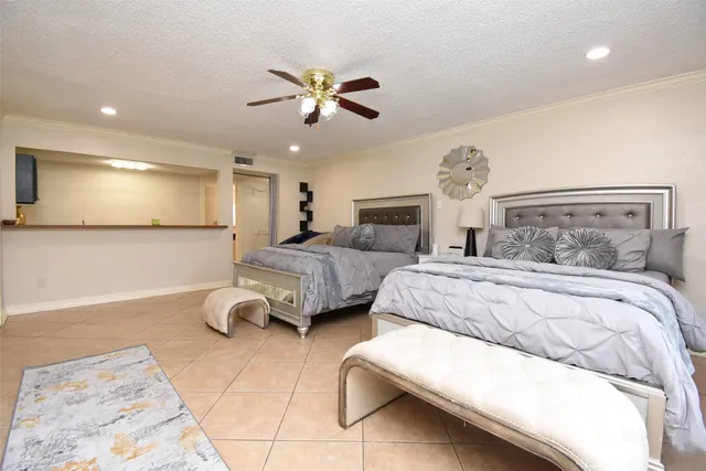 a spacious bedroom with a bed and a flat screen tv