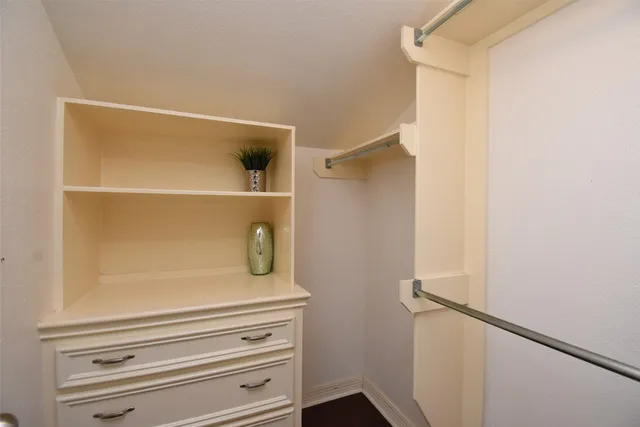a view of walk in closet with empty racks