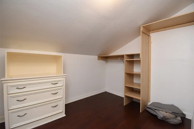 a view of a hallway with wooden floor and a bathroom view