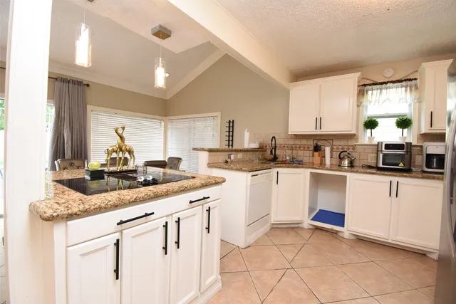 a kitchen with a sink and chairs