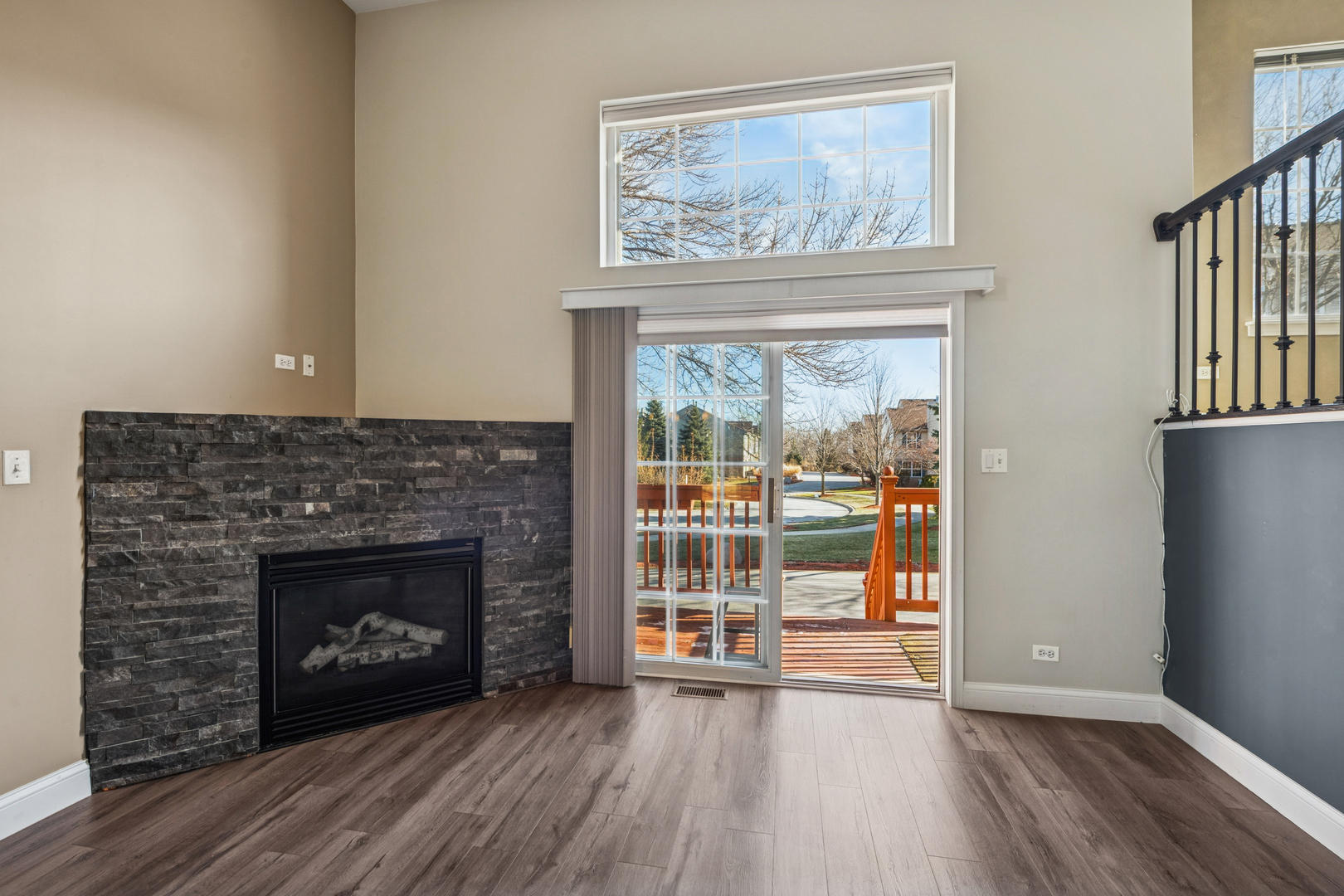 651 Georgian Court Addison, IL 60101 - Photo 5 of 24 an empty room with wooden floor fireplace and windows