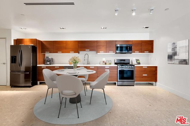 a dining room with a table chairs and kitchen view