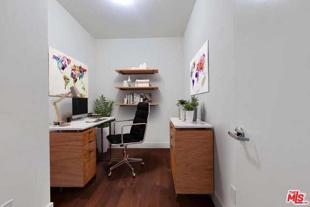 a view of a workspace with furniture and wooden floor
