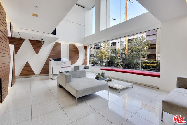 a living room with furniture and floor to ceiling window