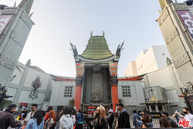 a group of people sitting in front of retail shop