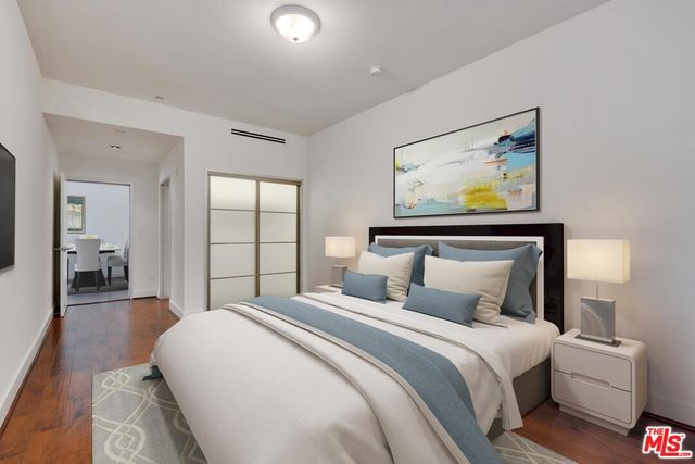 a bedroom with bed and painting on the wall