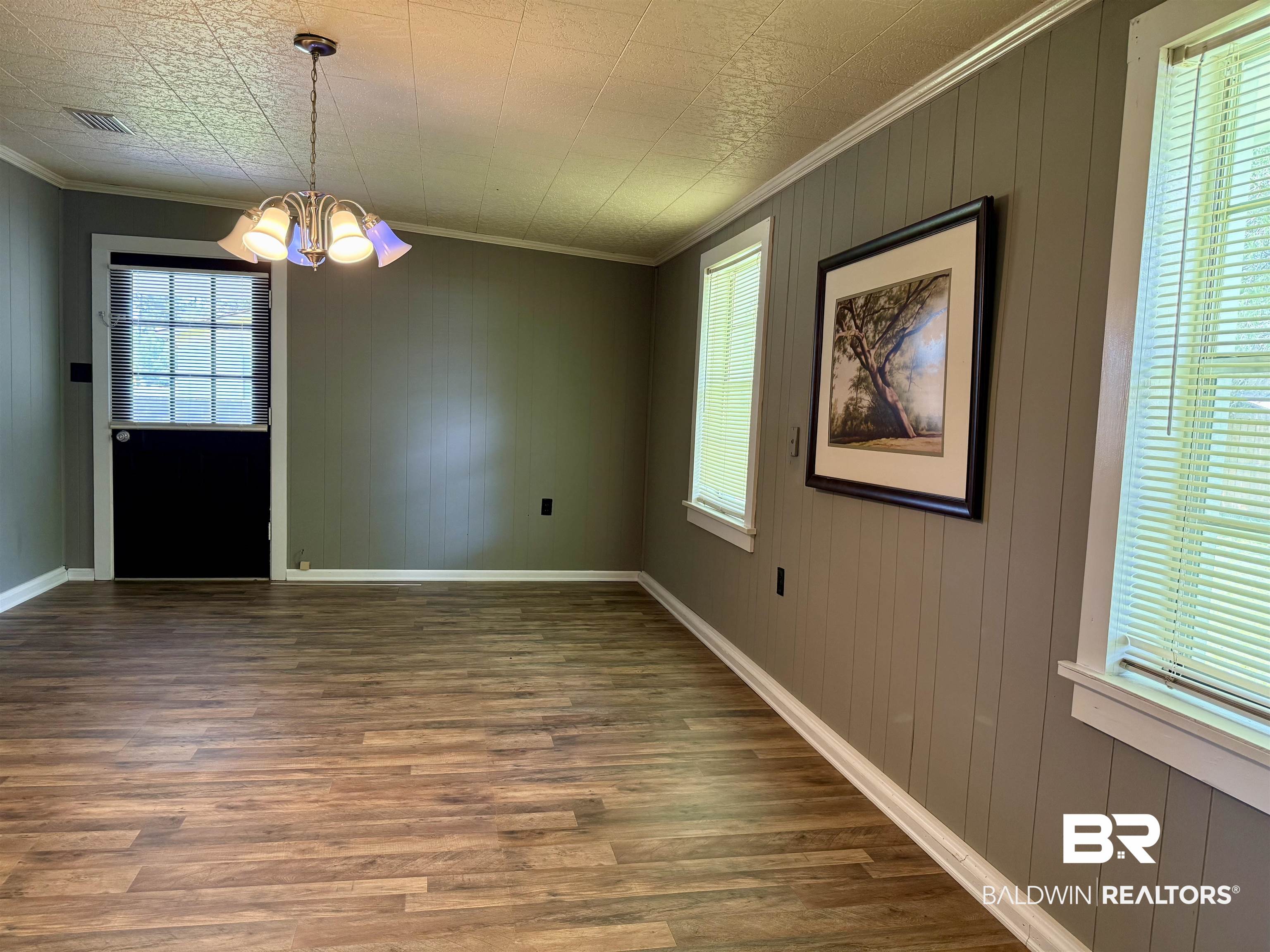 103 Kimberly Street Brewton, AL 36426 - Photo 8 of 18 Unfurnished dining area with a chandelier, wood finished floors, ornamental molding, and wooden walls