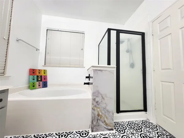 a bathroom with a tub a mirror and a sink