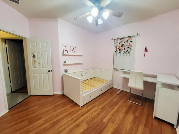 a view of a bedroom with wooden floor and cabinet