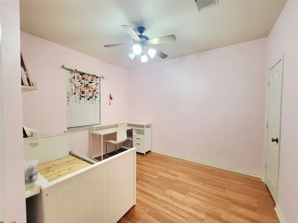 a room with a wooden floor and ceiling fan