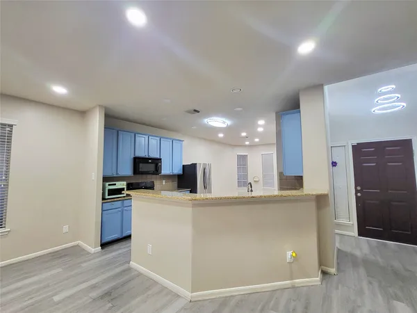 a kitchen with stainless steel appliances granite countertop a refrigerator a stove a sink and a microwave