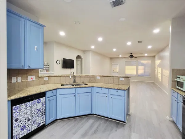 a kitchen with lots of counter space and wooden floor