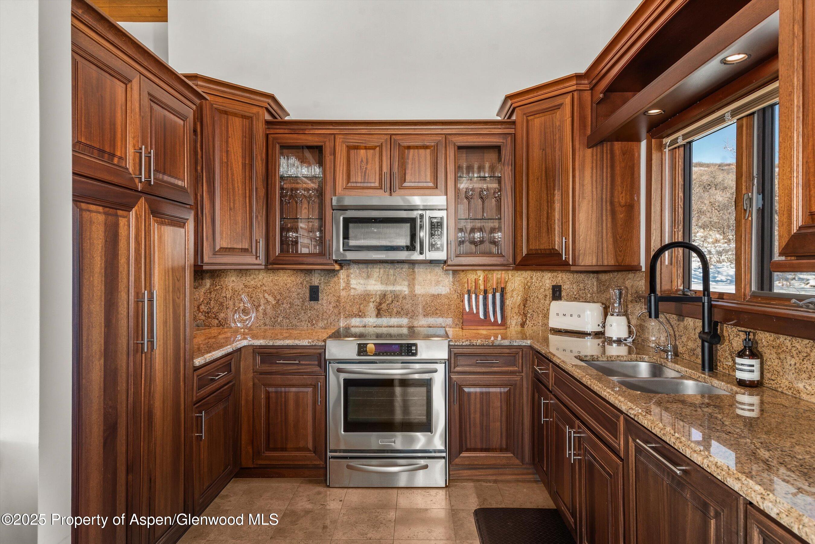 2227 Juniper Hill Road Aspen, CO 81611 - Photo 12 of 40 a kitchen with stainless steel appliances granite countertop a stove a sink and a microwave