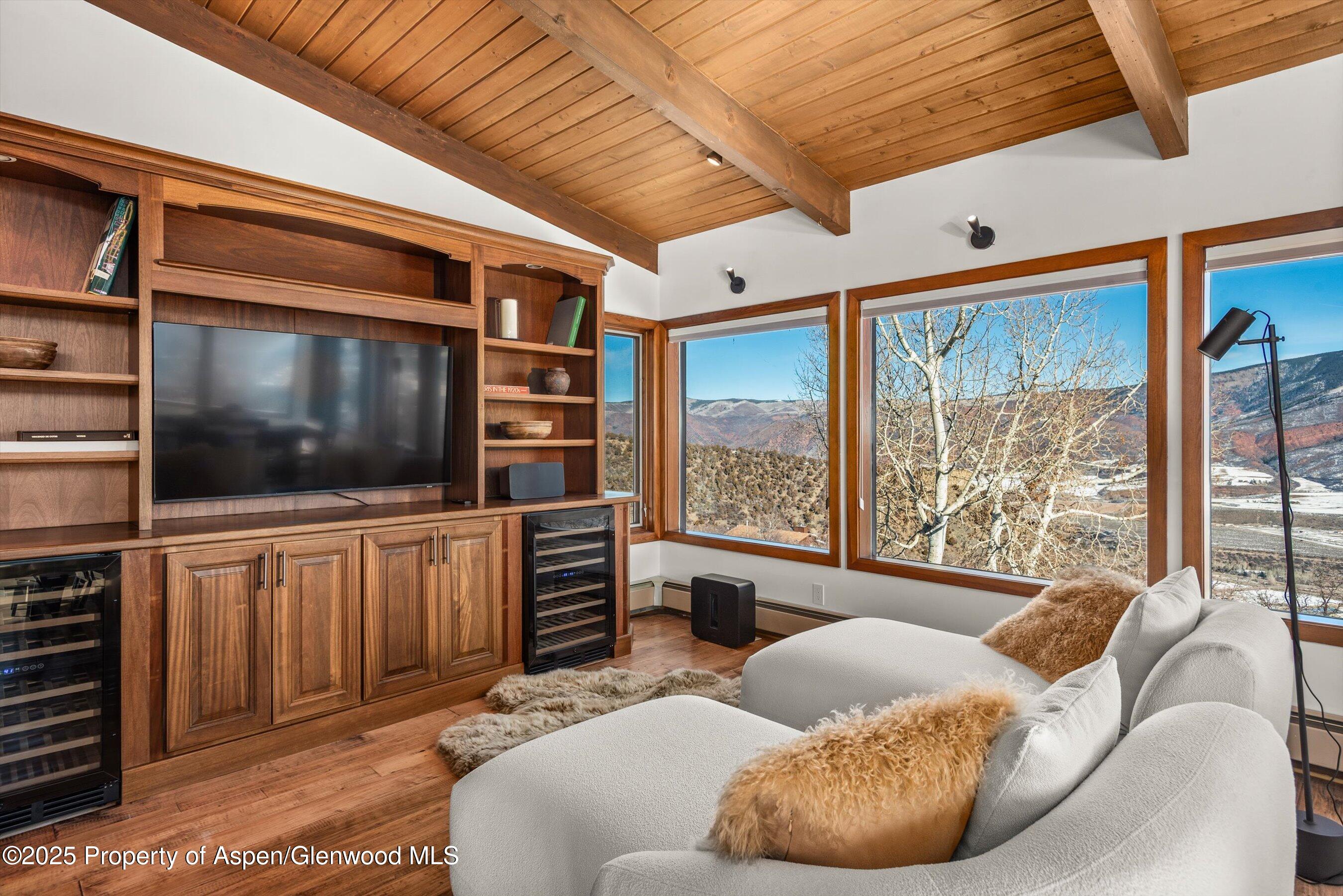 2227 Juniper Hill Road Aspen, CO 81611 - Photo 19 of 40 a living room with furniture a flat screen tv and a floor to ceiling window
