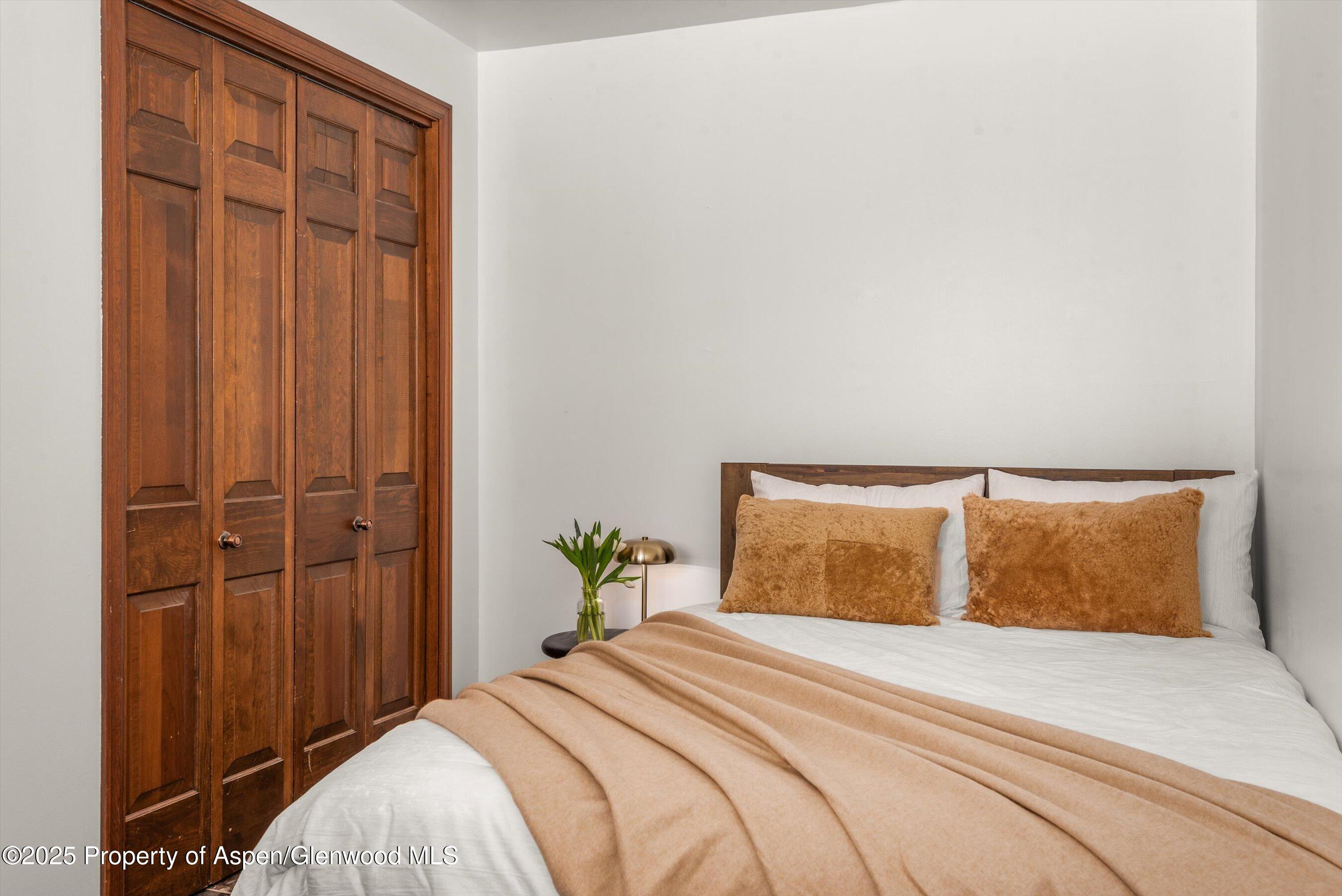 2227 Juniper Hill Road Aspen, CO 81611 - Photo 26 of 40 a bedroom with a bed and wooden floor