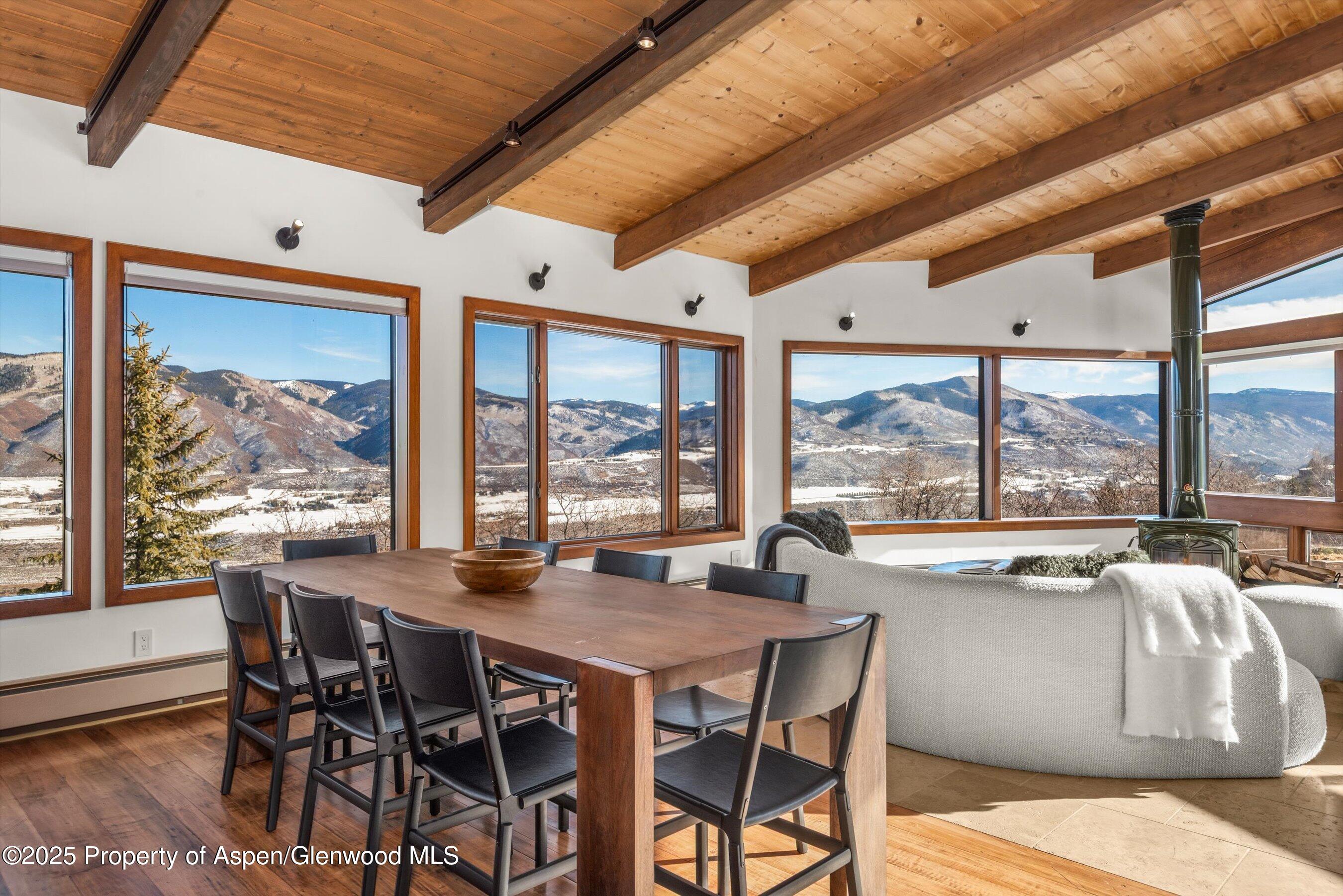 2227 Juniper Hill Road Aspen, CO 81611 - Photo 7 of 40 a dining room with furniture large windows and a chandelier