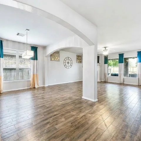 a kitchen with stainless steel appliances granite countertop a stove top oven a sink a dining table and chairs