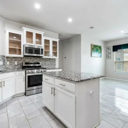 a kitchen with stainless steel appliances granite countertop a stove and a sink