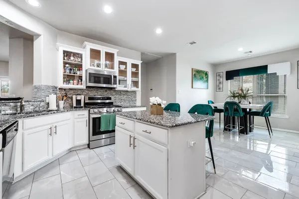 a kitchen with stainless steel appliances granite countertop a stove and a refrigerator
