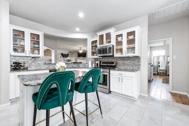 a view of a chair and table in backyard of the house