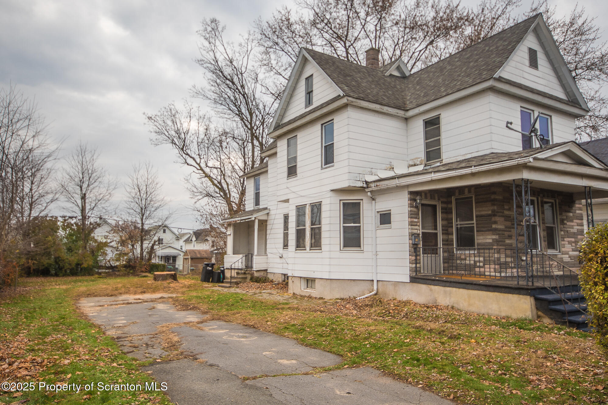 1227 Rundle Street Scranton, PA 18504 - Photo 4 of 43 a front view of a house with a yard covered with snow and trees