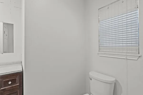 a white toilet sitting next to a white cabinet