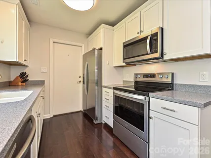 a kitchen with stainless steel appliances a stove microwave and sink