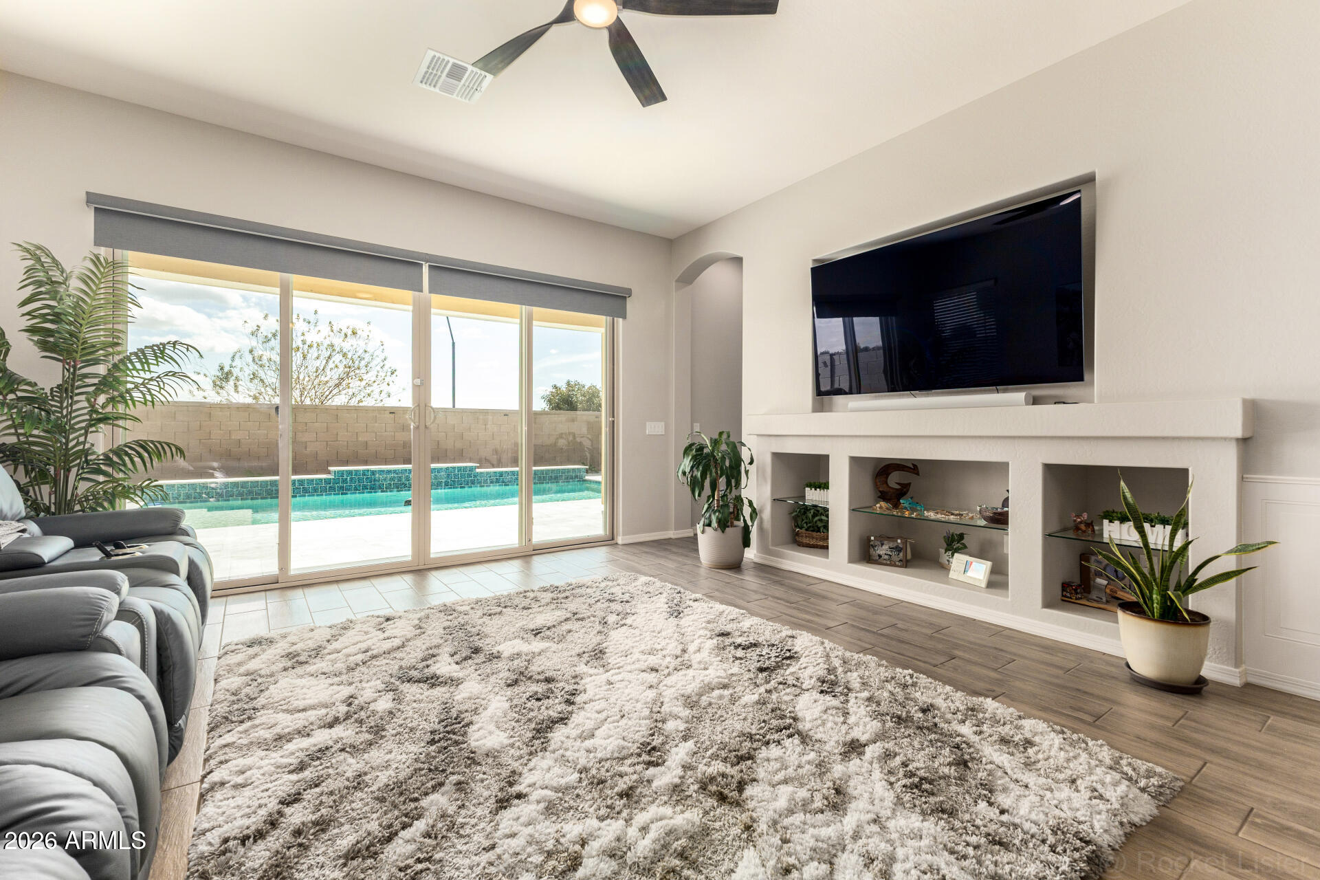 23135 East Thornton Road Queen Creek, AZ 85142 - Photo 12 of 61 a living room with fireplace a flat screen tv and a floor to ceiling window