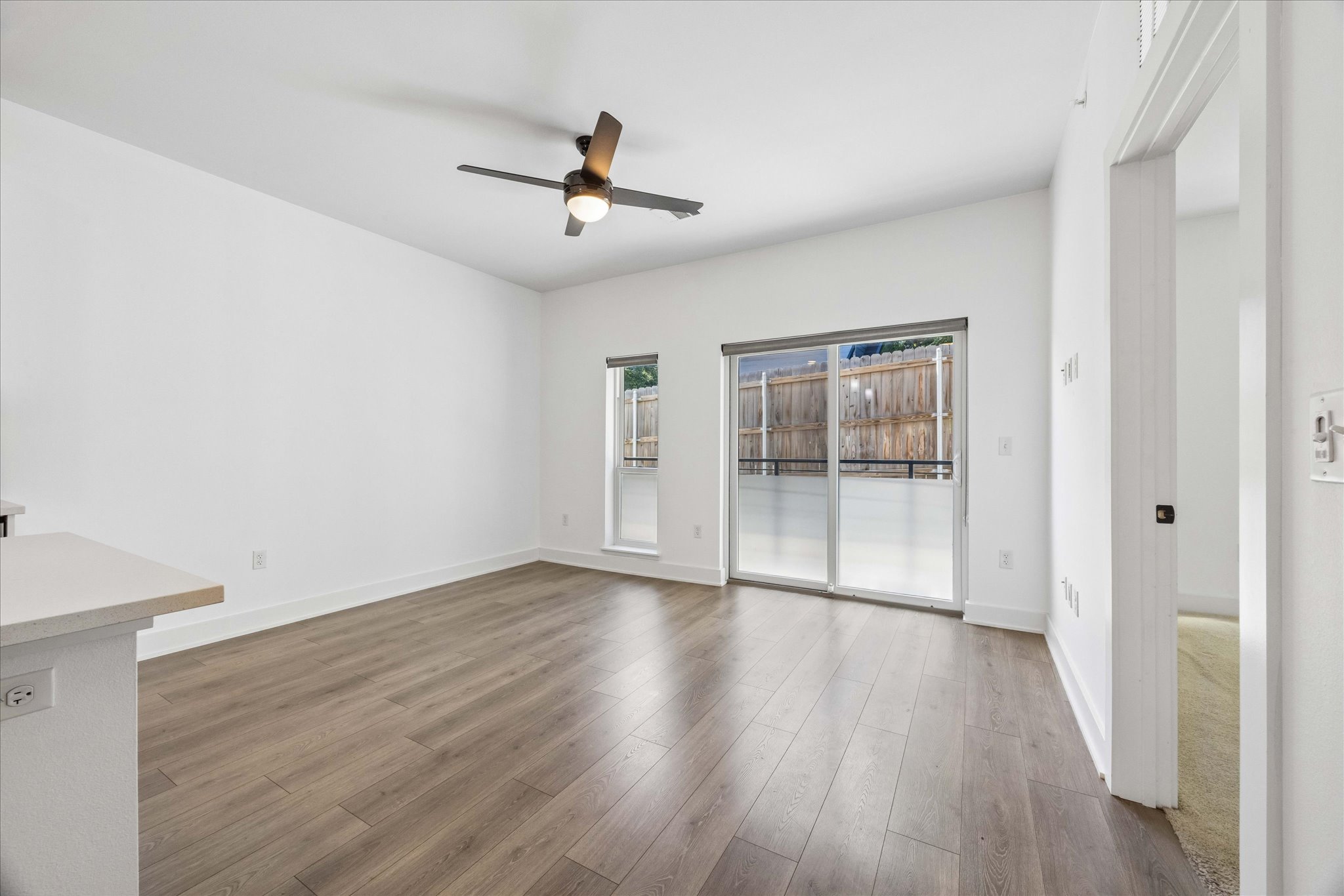 2220 Webberville Road, Unit 216 Austin, TX 78702 - Photo 12 of 26 Open-concept living area featuring wood-finish flooring, a modern ceiling fan, and a built-in countertop