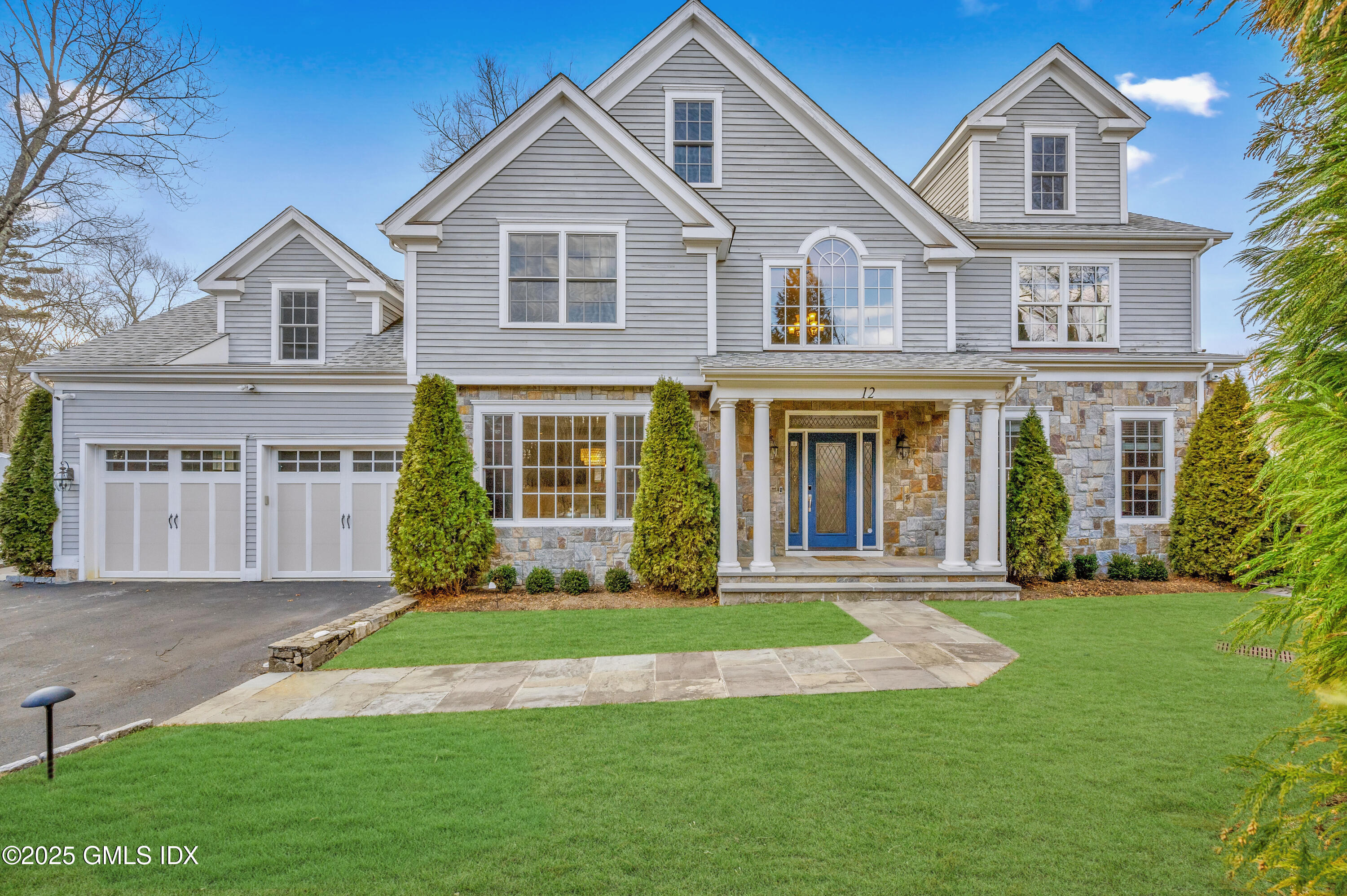 a front view of a house with a yard and green space
