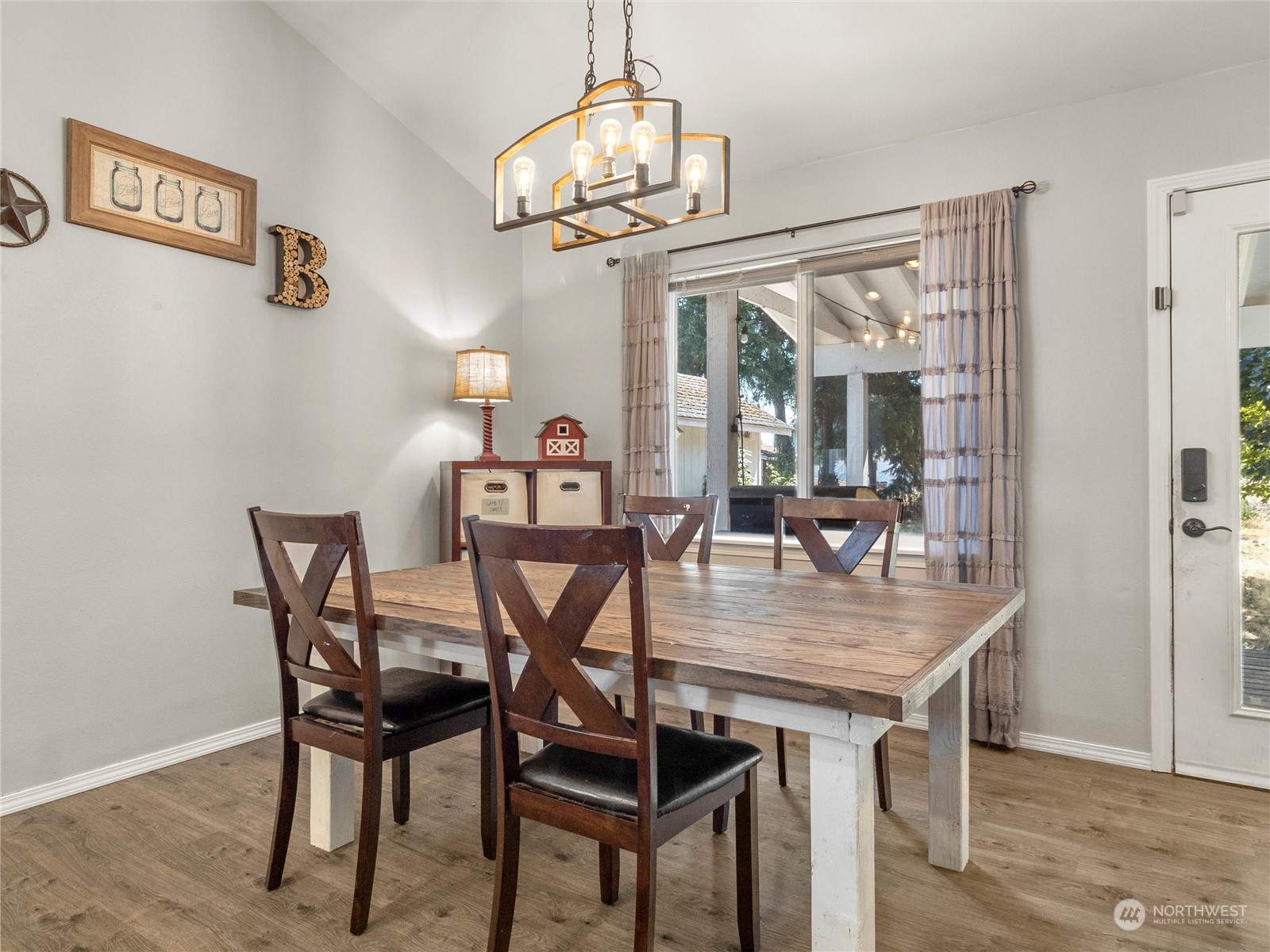 8643 194th Avenue Southwest Rochester, WA 98579 - Photo 14 of 28 a dining room with wooden floor a chandelier a wooden table and chairs