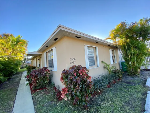a front view of house with a garden