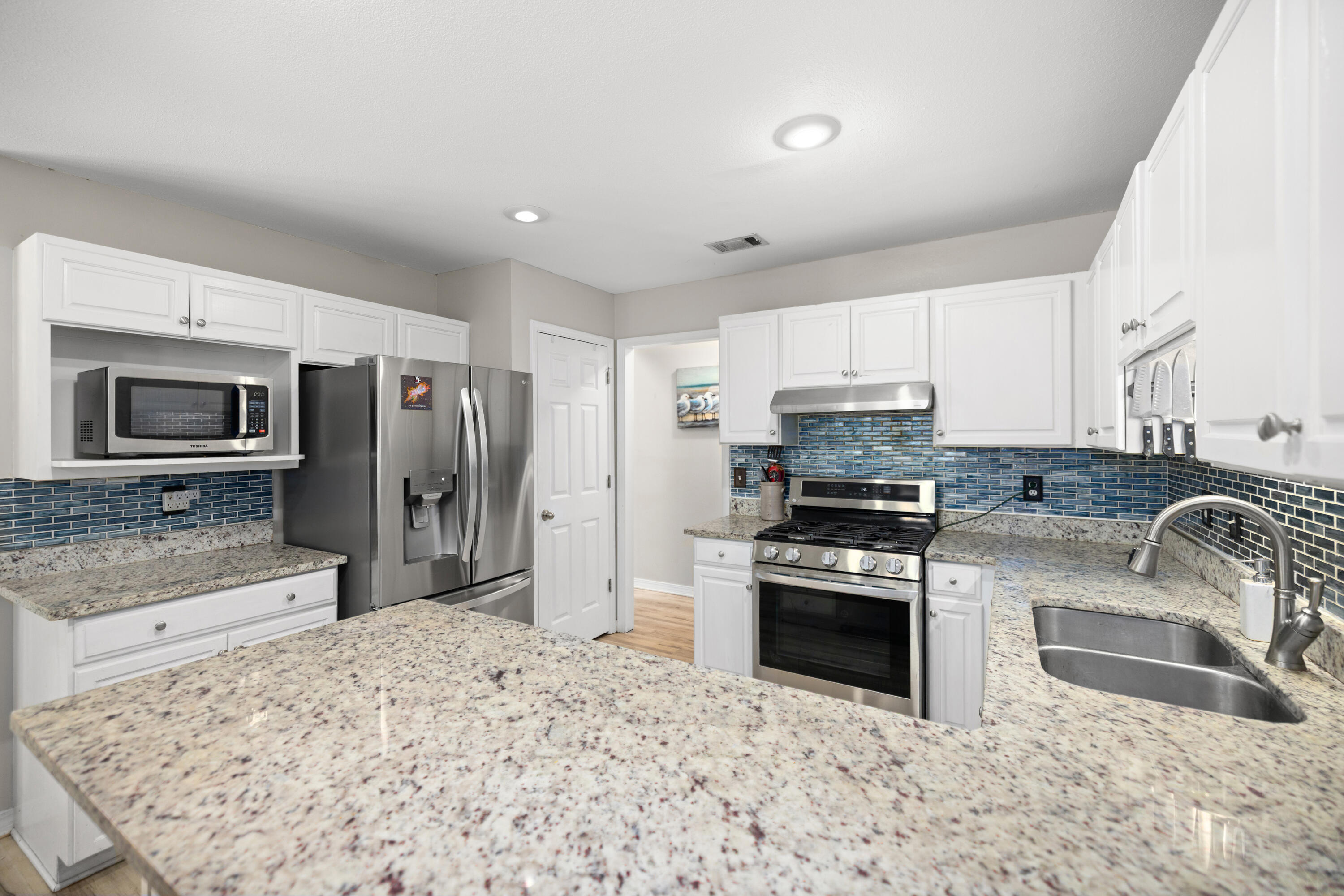 314 Ruckel Drive Niceville, FL 32578 - Photo 19 of 66 a kitchen with stainless steel appliances granite countertop a sink stove and refrigerator