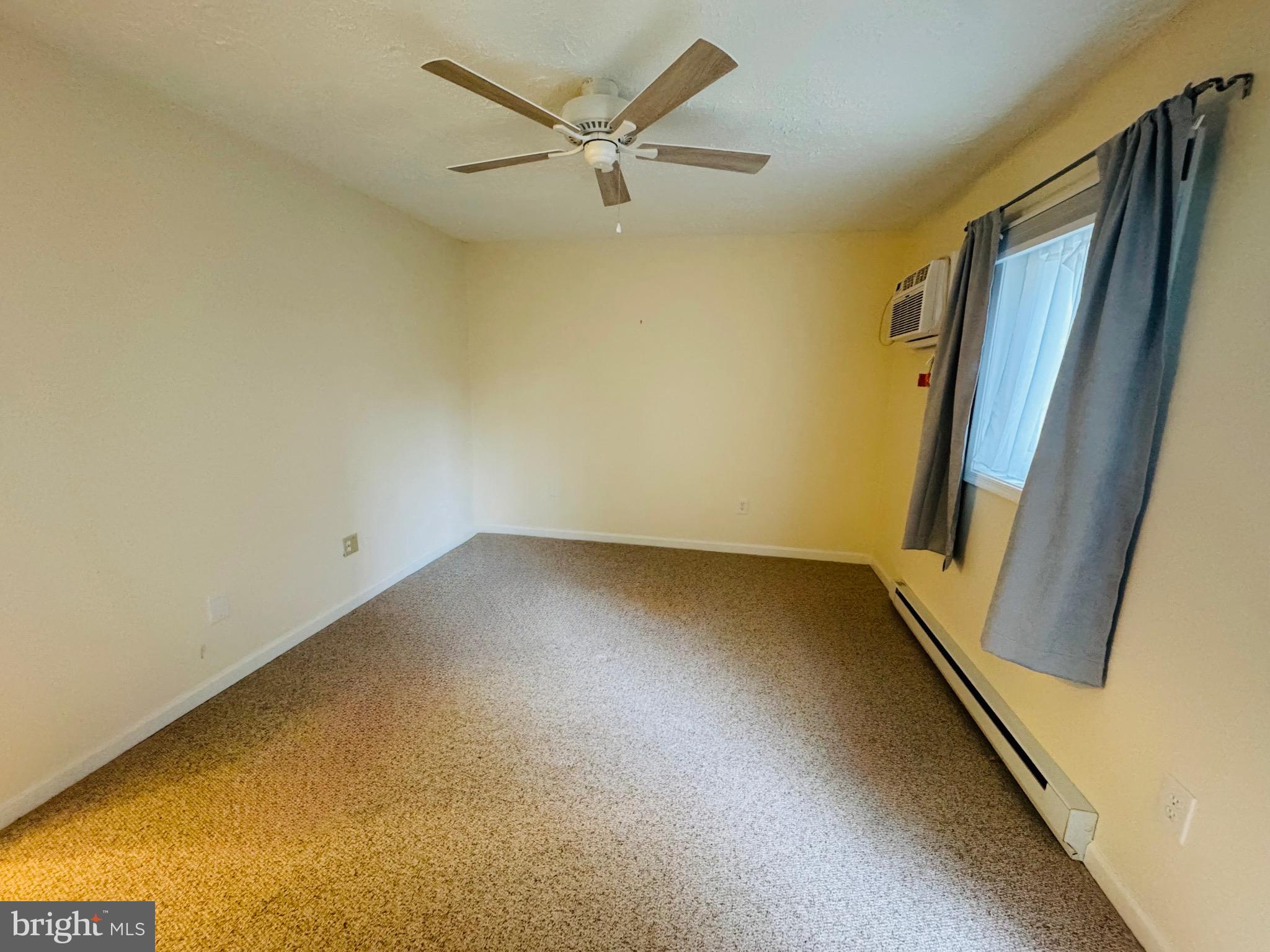 14400 Jarvis Avenue, Unit 113C Ocean City, MD 21842 - Photo 11 of 19 an empty room with a ceiling fan and wooden floor