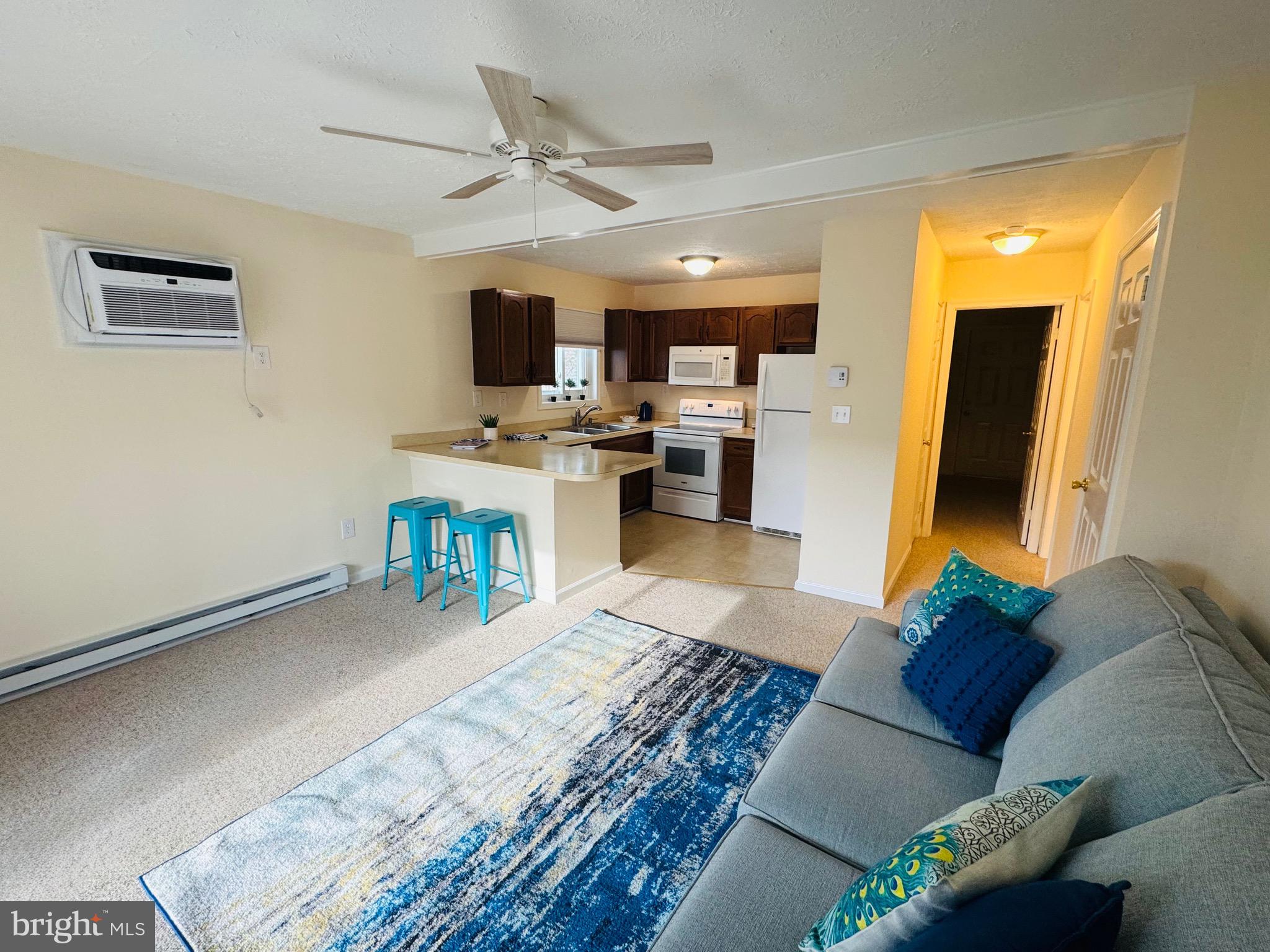 14400 Jarvis Avenue, Unit 113C Ocean City, MD 21842 - Photo 4 of 19 a living room with furniture and a flat screen tv