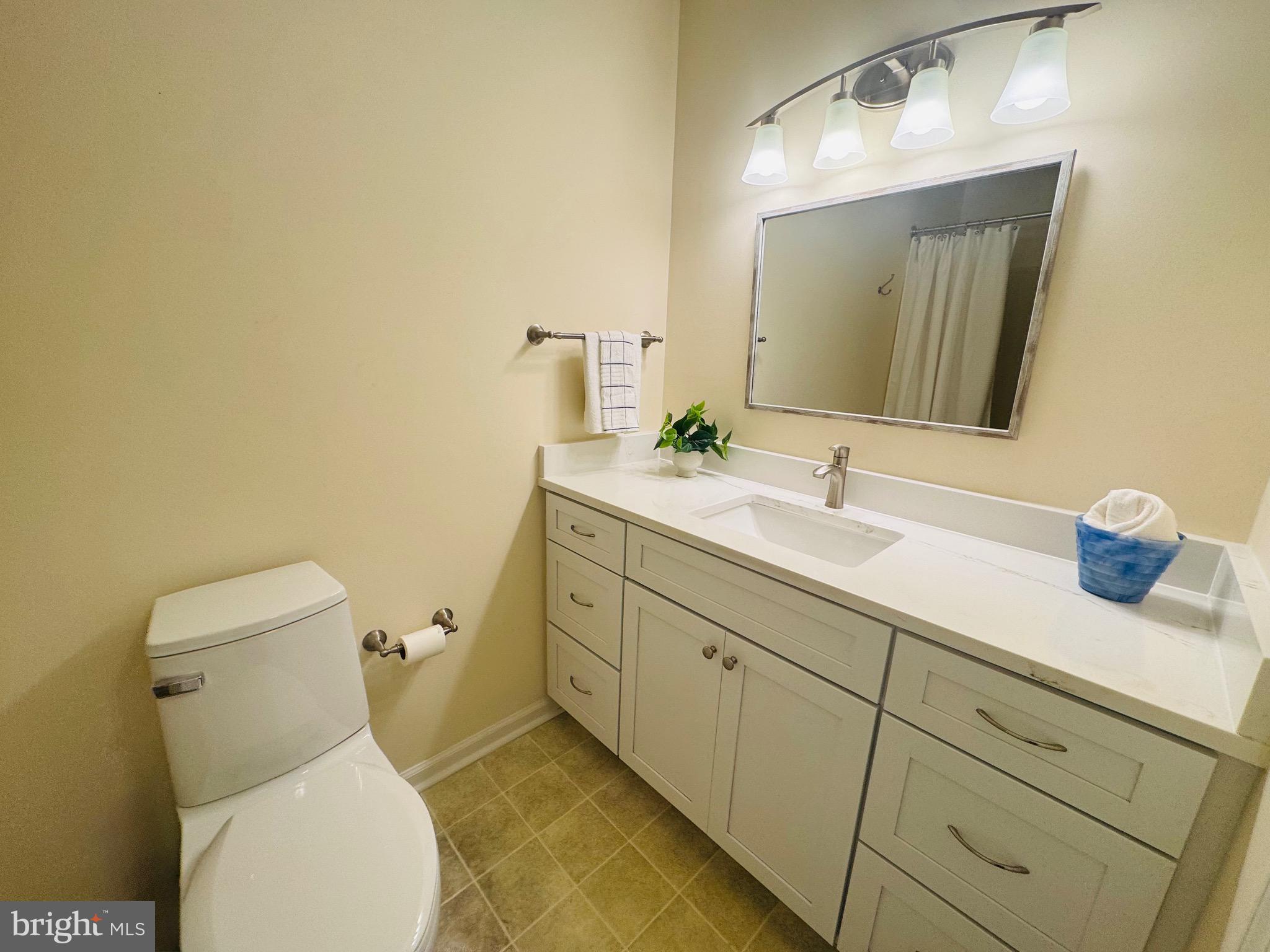 14400 Jarvis Avenue, Unit 113C Ocean City, MD 21842 - Photo 9 of 19 a bathroom with a toilet sink and mirror