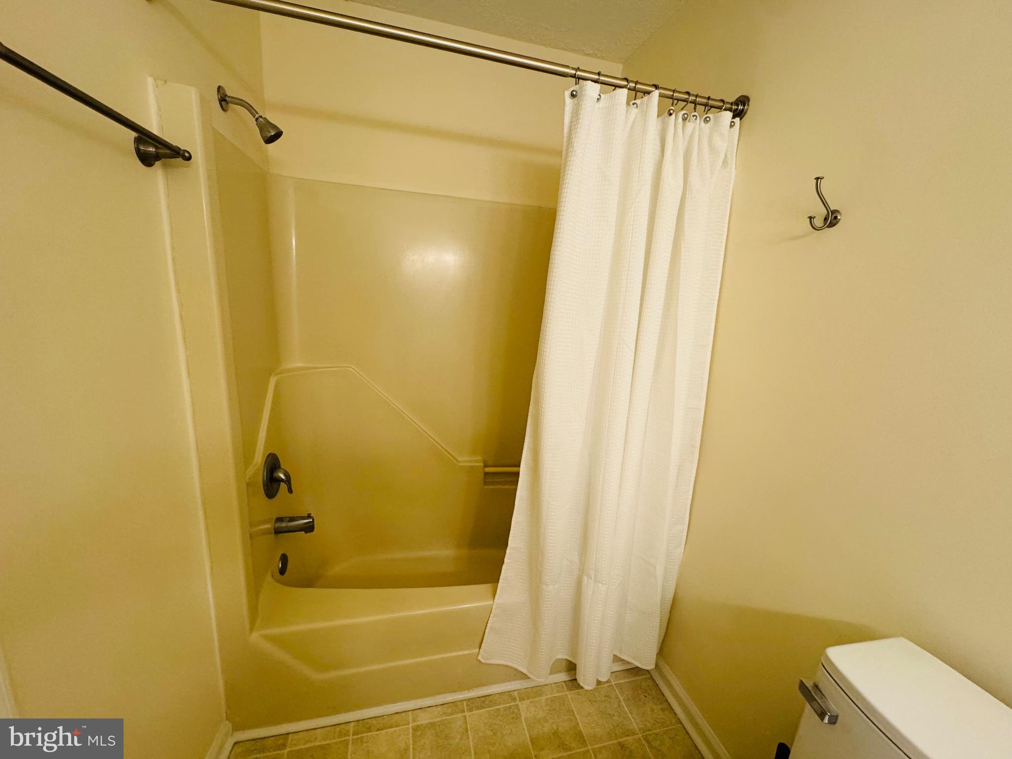 14400 Jarvis Avenue, Unit 113C Ocean City, MD 21842 - Photo 10 of 19 a bathroom with a shower and a toilet