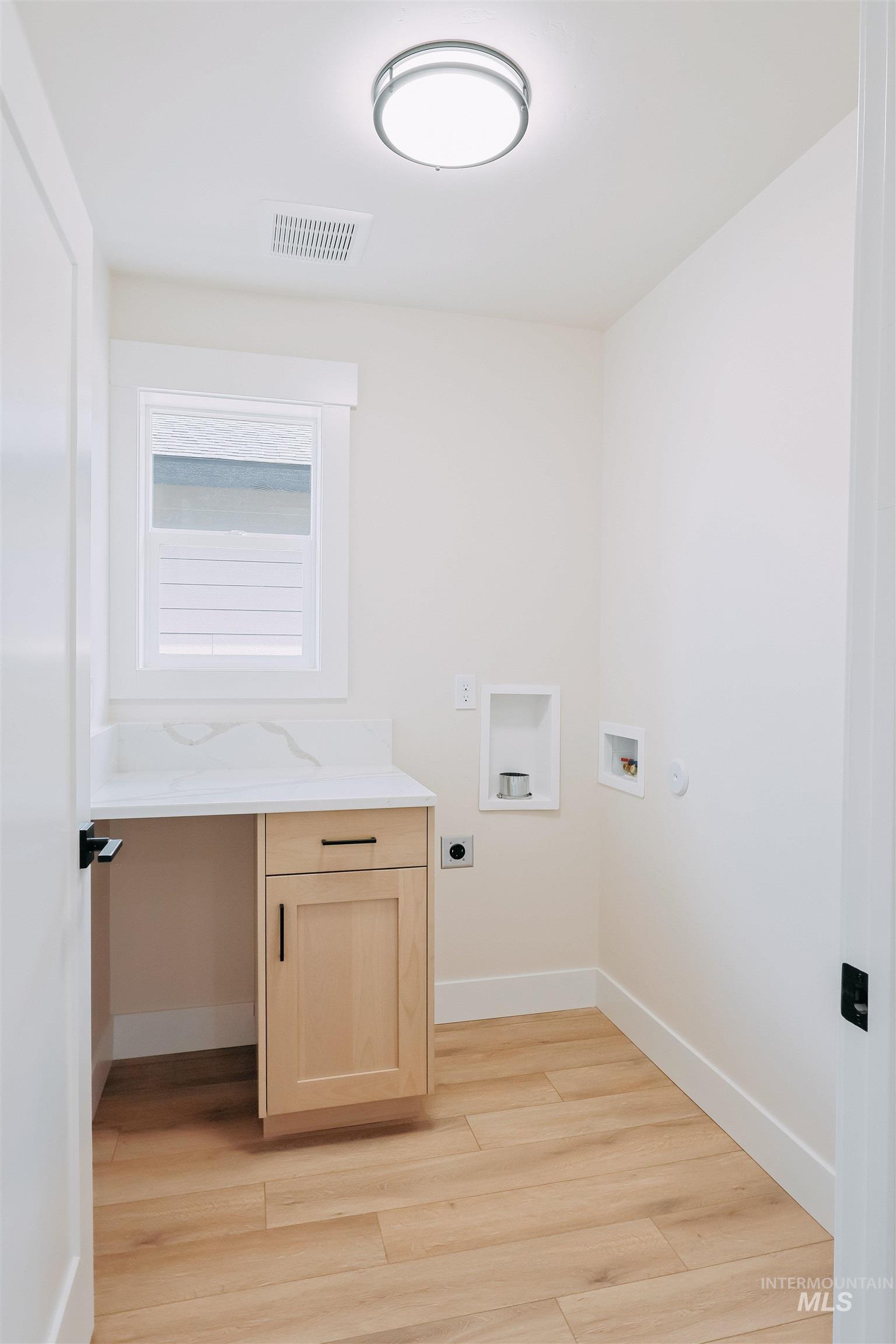 10 North Crk Way Cascade, ID 83611 - Photo 12 of 25 Laundry area with an office area, hookup for a washing machine, light wood-type flooring, hookup for an electric dryer, and cabinet space