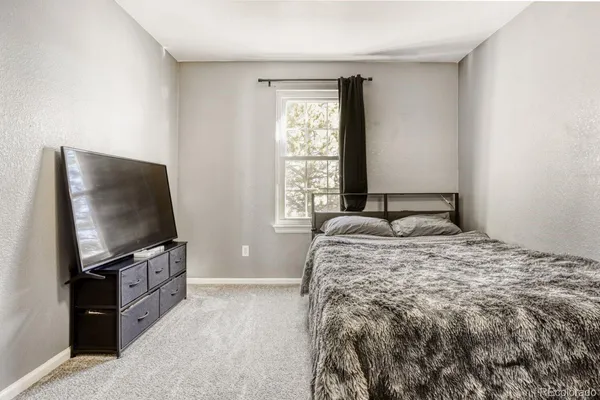 a bedroom with a bed and a flat screen tv