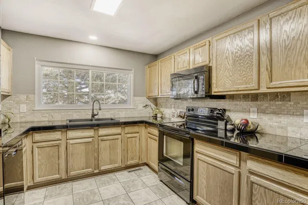 a kitchen with stainless steel appliances granite countertop a sink a stove and cabinets