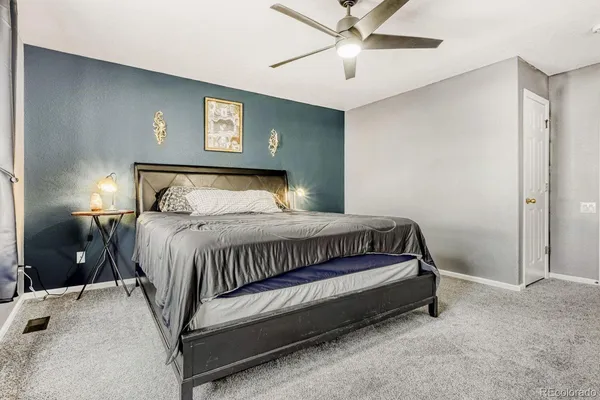 a bed sitting in a bedroom next to a lamp