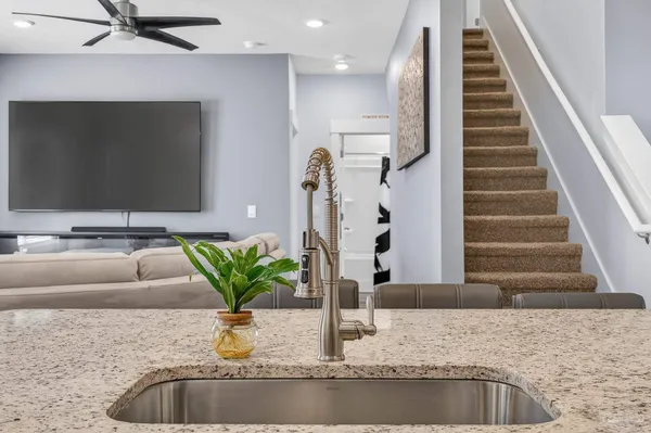 a kitchen with stainless steel appliances granite countertop a stove top oven a sink dishwasher and white cabinets with wooden floor