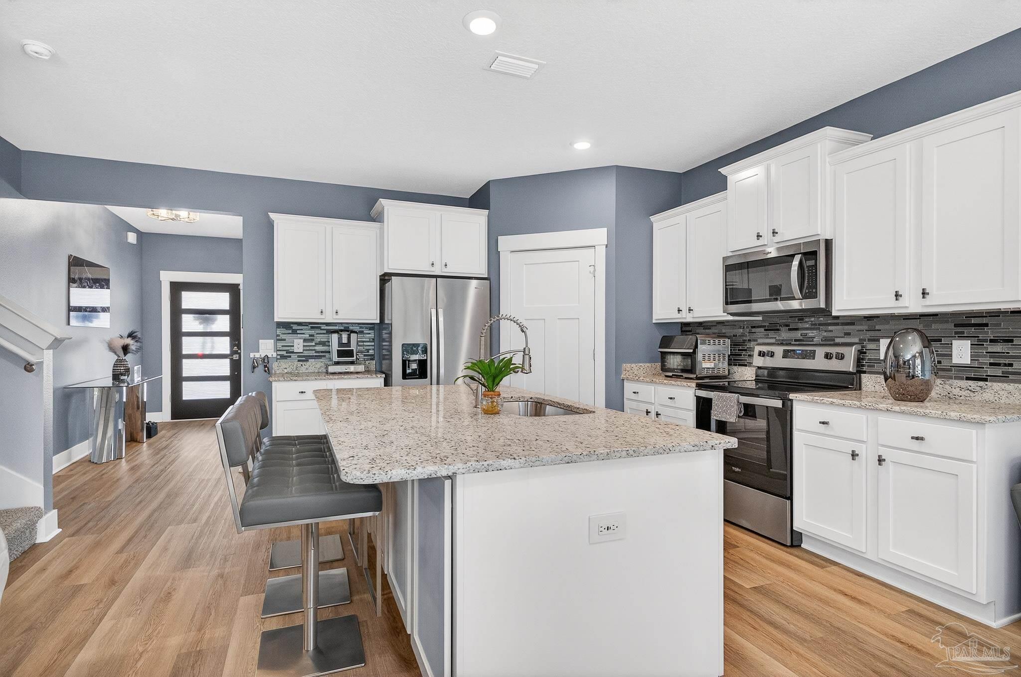 6076 Rutherford Loop Pensacola, FL 32526 - Photo 18 of 67 a kitchen with stainless steel appliances kitchen island granite countertop a stove refrigerator and cabinets