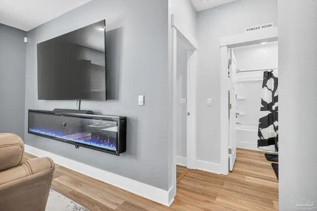 a large white kitchen with stainless steel appliances kitchen island a stove a refrigerator a oven with white cabinets and wooden floor