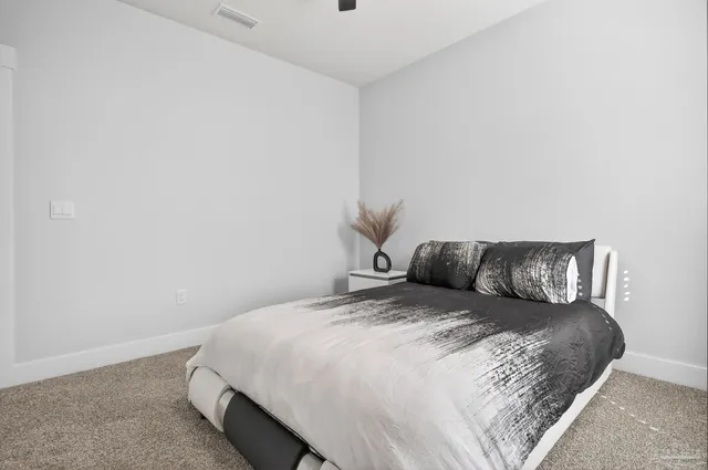 a view of a bedroom with a large bed and a mirror