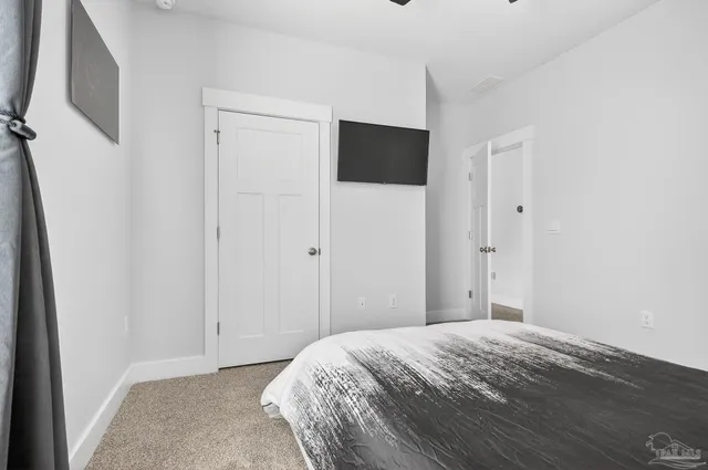 a spacious bedroom with a bed and a flat screen television